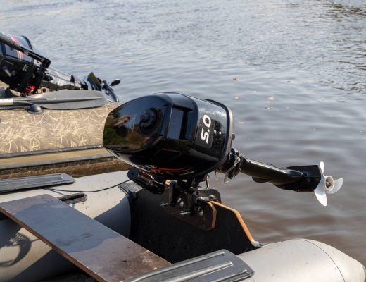 The ends of two pontoon rafts moored next to each other in a brown lake, their black outboard motors lifted out of the water.