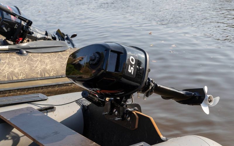 The ends of two pontoon rafts moored next to each other in a brown lake, their black outboard motors lifted out of the water.