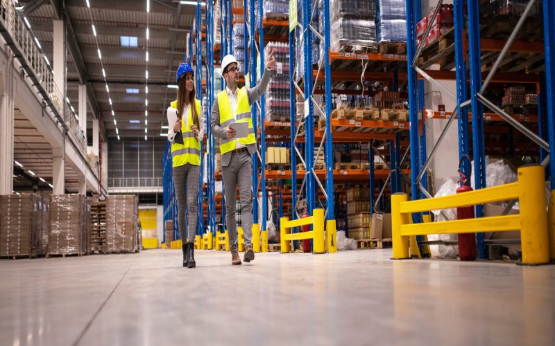 Two managers walking through the facility and looking at the shelving units. One of them is pointing at something.