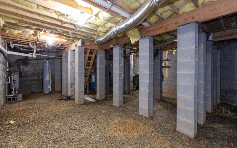 A close-up of a newly renovated crawl space in a home with concrete beams to help support the house's roof.