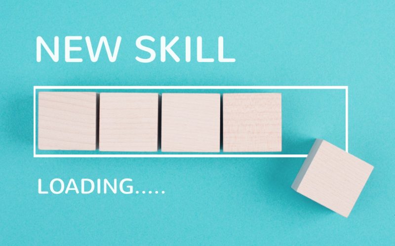 A piece of teal paper that reads "New Skill" and "Loading..."; in-between is a rectangular outline with blocks placed within.