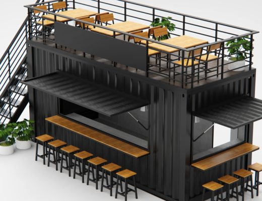 Black shipping container café with rooftop patio, outdoor bar seating, metal staircase, and modern tables with plants.